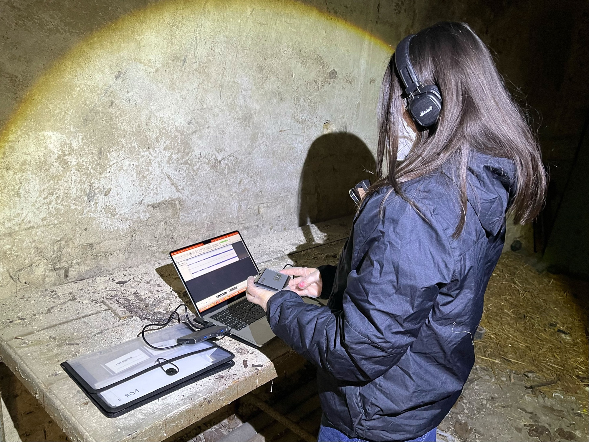 Digitizing cassette tapes on site with headphones and a laptop